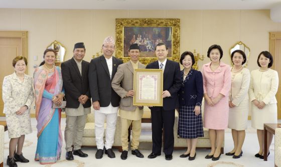 尼泊尔全国专业摄影师协会主席（左5）将证书颁给池田博正主任副会长（右5）